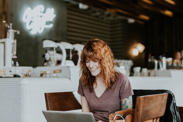 A woman writing on a laptop